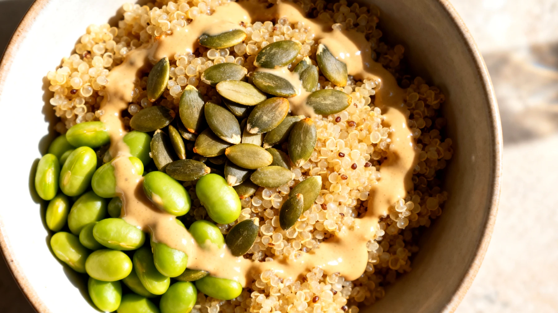 Amaranth-Quinoa-Bowl mit Kürbiskernen, Edamame und Tahini-Dressing"