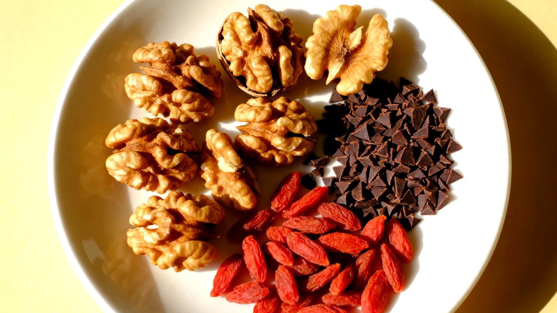 Walnüsse mit dunklen Kakao-Nibs und getrockneten Gojibeeren"